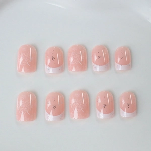 Short press-on nails with white maple leaf designs and french tips on pink base