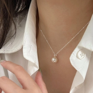 Close-up of minimalist 8mm pearl pendant on S925 silver chain worn on the neck