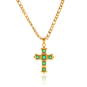 Detail of gold Figaro chain necklace with a green zircon inlaid cross pendant on white back