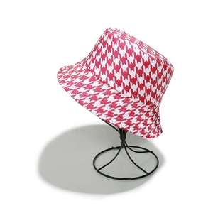 Dettaglio del cappello alla pescatora pied de poule rosa e bianco su supporto in metallo