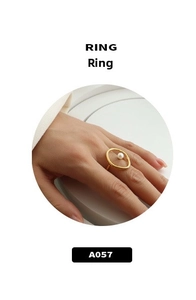 Close-up of minimalist gold oval ring with white pearl inlay worn on finger