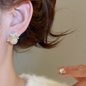 Detail of luxury pearl and zircon fireworks stud earrings on model for elegant style