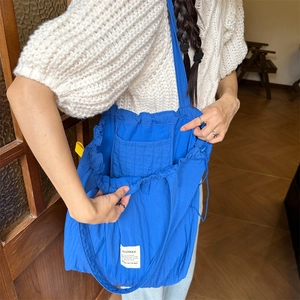 Detail of blue striped tote bag showing inner compartments and spacious interior capacity