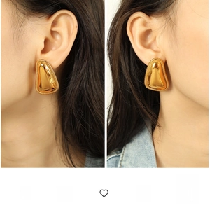 Detailed view of irregular 18K gold teardrop earrings with textured rope edge on model