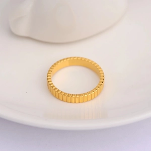 Macro detail of gold grosgrain texture on an irregular wave ring made of stainless steel