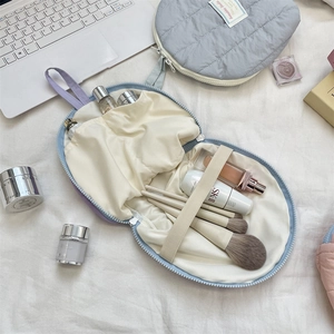 Detail view of the interior layout with elastic brush loops in a quilted cosmetic bag