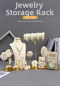 Detail of cream velvet jewelry stands with gold metal base for rings and necklaces