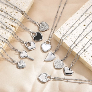 Elegant heart pendant necklaces in silver and black finishes on luxury silk display