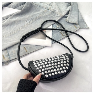 Detail of a black crescent crossbody bag with silver studs and braided strap details