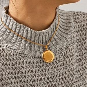 Gros plan détaillé d'un collier médaillon vintage plaqué or 18 carats porté par un mannequin