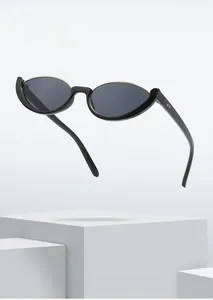 Occhiali da sole cat-eye retrò con montatura nera e accenti dorati su base di pietra