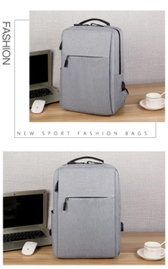 Detail view of grey business laptop backpack with USB port on a wooden office desk