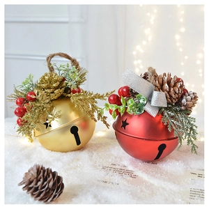 Close-up of red and gold Christmas bells with pine cones on white snow background