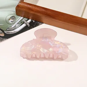 Close-up of pink pearlescent PVC hair claw clip with glossy shell texture finish