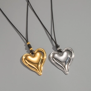 Gros plan de pendentifs en cœur or et argent sur des colliers en cordon noir fins