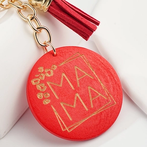 Macro shot of red wooden Mama keychain with leopard print, golden chain and red tassel