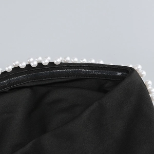 Detail showing white pearl trim and silicone non-slip strip on the black tube dress