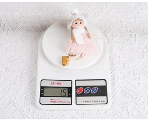 Close-up of a handmade plush Christmas ornament weighing 15g on an electronic scale