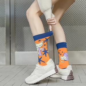 Detail showing elastic ribbing and cartoon cat motif on orange and blue cotton socks
