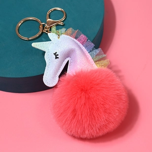 Primer plano de llavero de unicornio con pompón rosa brillante y encaje decorativo