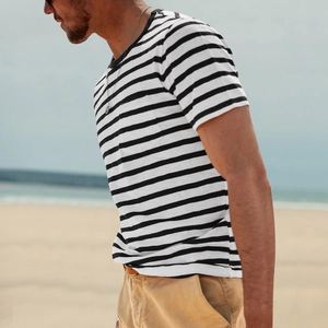 Outdoor lifestyle shot of a man wearing a black and white striped short sleeve t-shirt