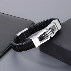 Detail of black braided leather bracelet with silver buckle and geometric metal accents