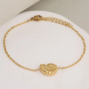 Bracelet minimaliste en acier doré avec pendentif coquillage 3D sur un support blanc