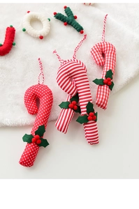 Close-up of red and white plush candy canes and JOY ornaments on a white fur rug