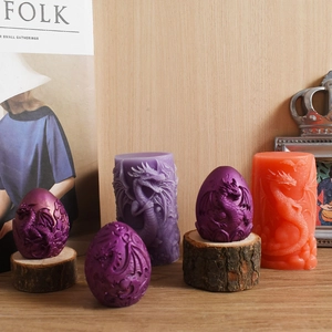 Detailed relief dragon pattern on cylindrical and egg-shaped colored wax candles