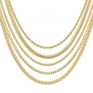 Primer plano de cinco collares de acero de titanio dorado con varios diseños de eslabones