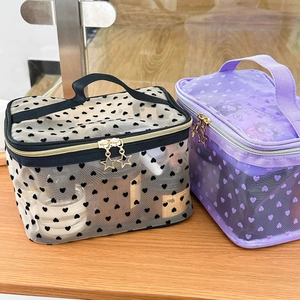 Detail of mesh makeup bags with purple heart patterns and star-shaped metal zippers