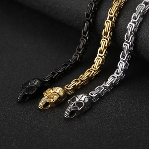 Detailed view of skull clasps on black, gold, and silver stainless steel box chains