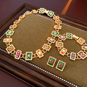 Close-up of vintage flower and bow jewelry set with enamel and rhinestones on wood