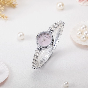 Detail of pink mother-of-pearl dial and pearl bead strap on elegant luxury women's watch
