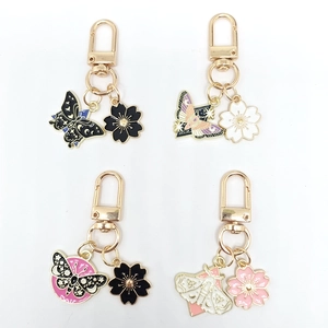 Set of four butterfly and cherry blossom enamel keychains in black, white, and pink finish