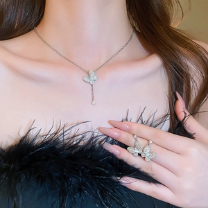 Close-up of model wearing silver butterfly necklace and earrings with zircon tassel