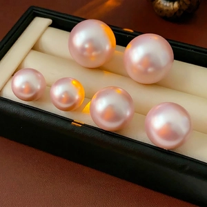 Minimalist round pink pearl stud earrings in various sizes with high metallic luster