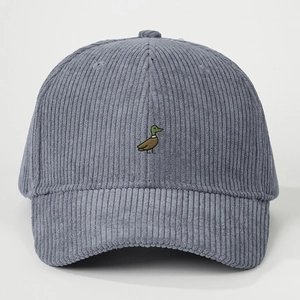 Detailed embroidery of a colorful mallard duck on blue corduroy baseball cap texture