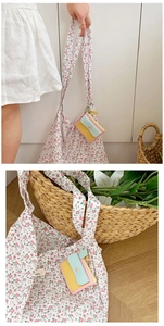 Detail view of a floral tote bag and a colorful mini coin purse with snap closure