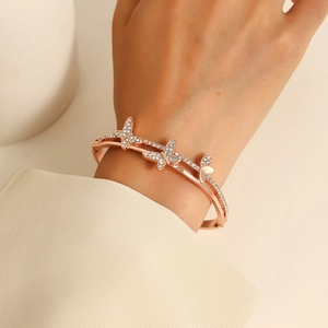 Bracciale rigido a farfalla in oro rosa con cristalli di zircone in un design aperto