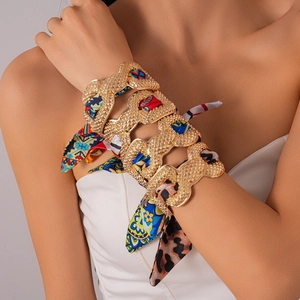 Set of four gold scale-textured metal bangles wrapped in vibrant patterned silk scarves