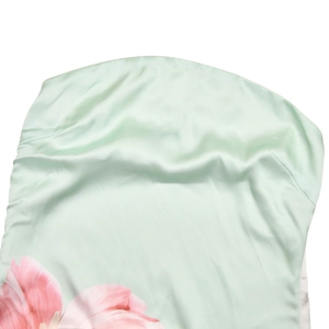 Gros plan du tissu en satin vert clair avec des motifs floraux roses élégants