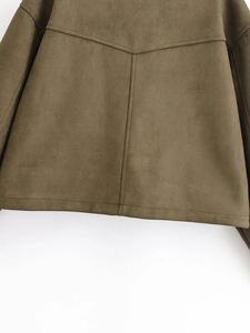 Vue macro d'une veste en daim montrant les coutures détaillées et la texture mate douce