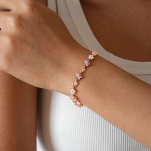 Elegant flower link bracelet with pearls and lilac crystals worn on a model wrist