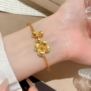 Detailed macro view of 24K gold-plated beaded flower bracelet with matte hammered texture