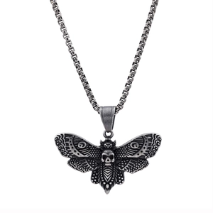 Collier tête de mort et papillon vintage argenté avec pendentif détaillé sur fond blanc