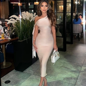 Detail view of a beige one-shoulder bodycon dress with elegant draping in a luxury setting