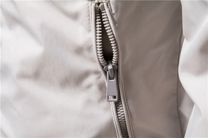 Close-up of a premium light gray injection zipper on a men's stand collar casual jacket