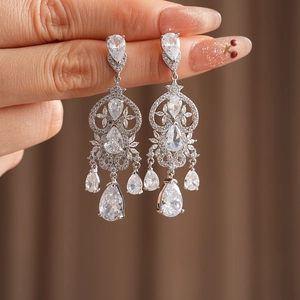 Macro view of crystal drop tassel earrings with zircon floral accents and silver finish