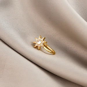 Detailed close-up of a gold U-shaped non-piercing star nose clip with micro-set zircon